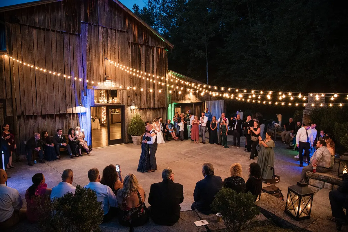 The courtyard at night, string lights overhead and guests dancing